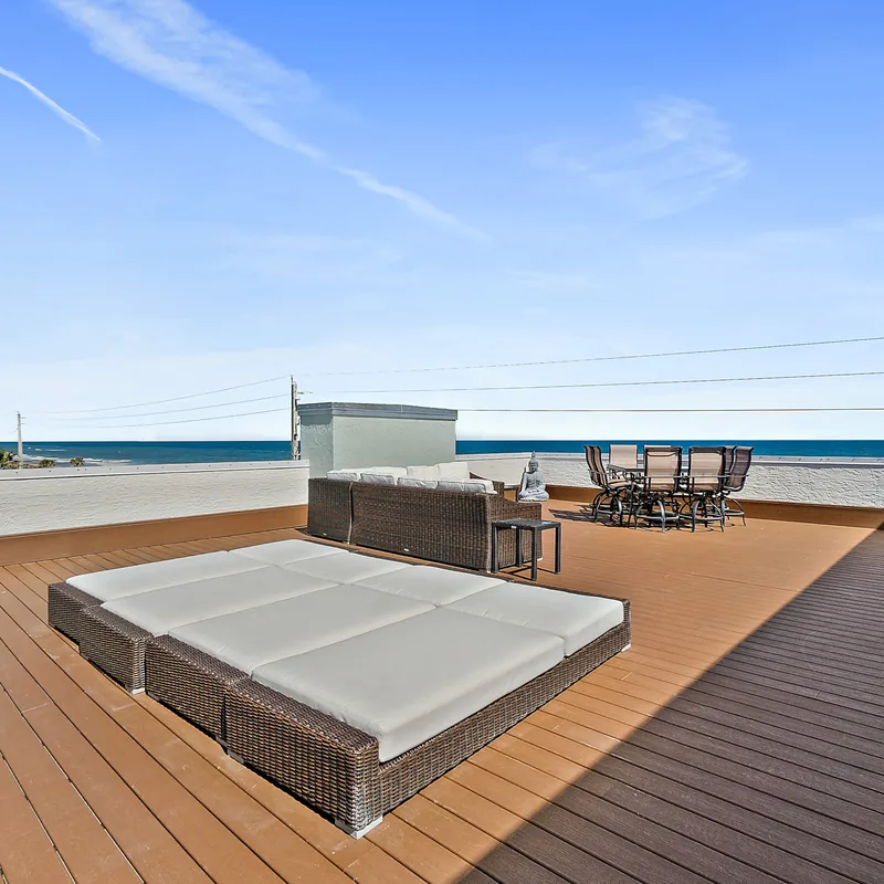 Rooftop sun deck with loungers and panoramic ocean views at the Ormond-by-the-Sea penthouse